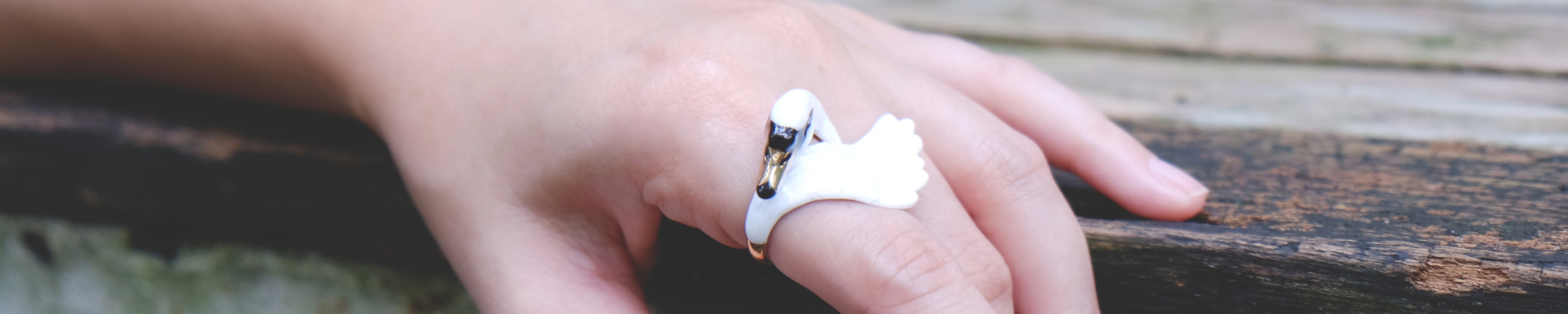 A hand wearing a beautiful swan ring