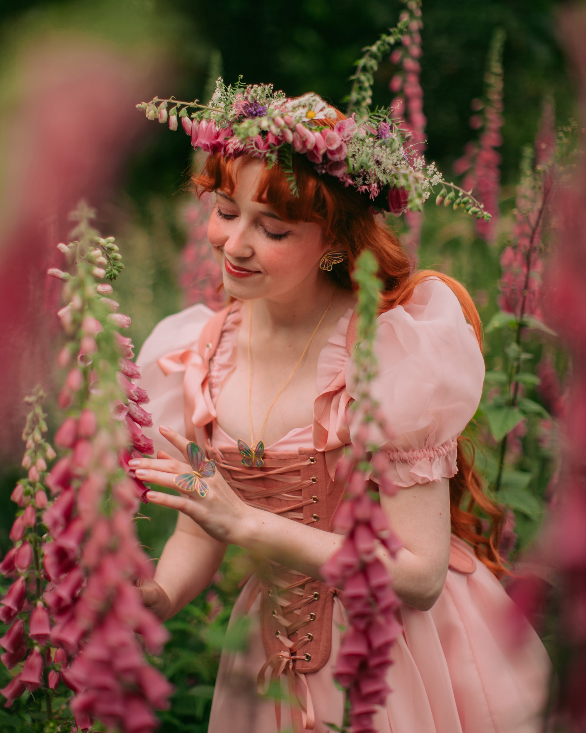 Elegant fairy butterfly ring, earrings and necklace set worn in a floral garden.