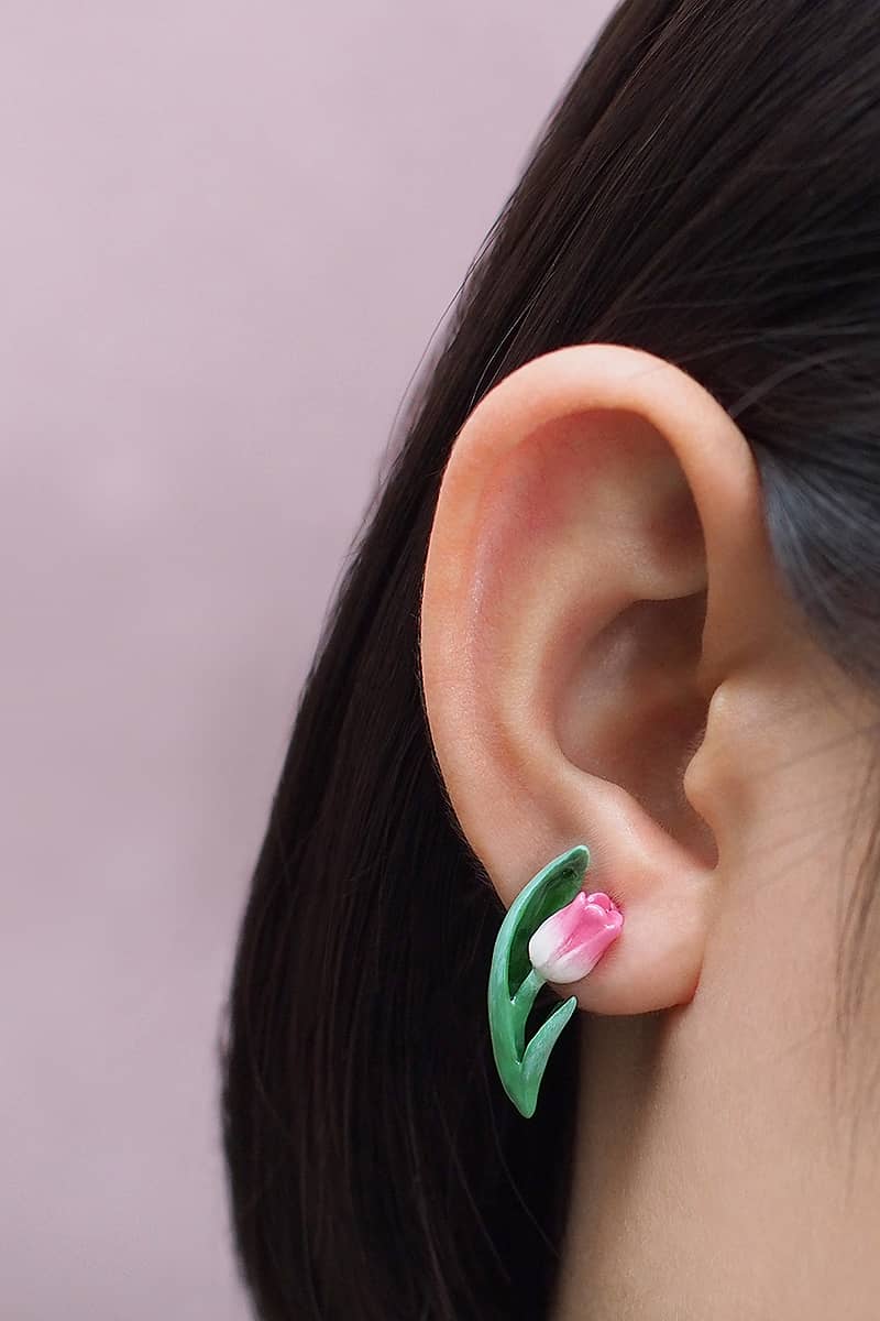 Close-up of an tulip earrings worn on a woman's ear.