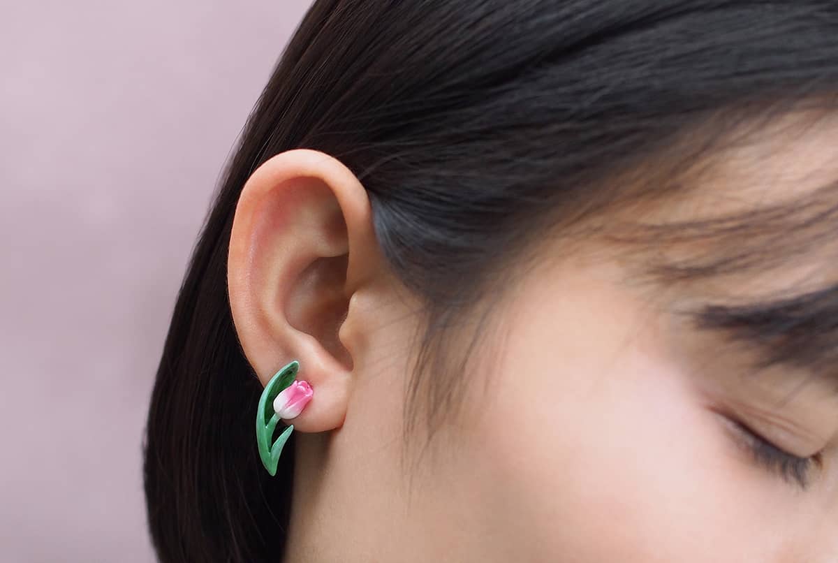 Close-up of an tulip earrings worn on a woman's ear.