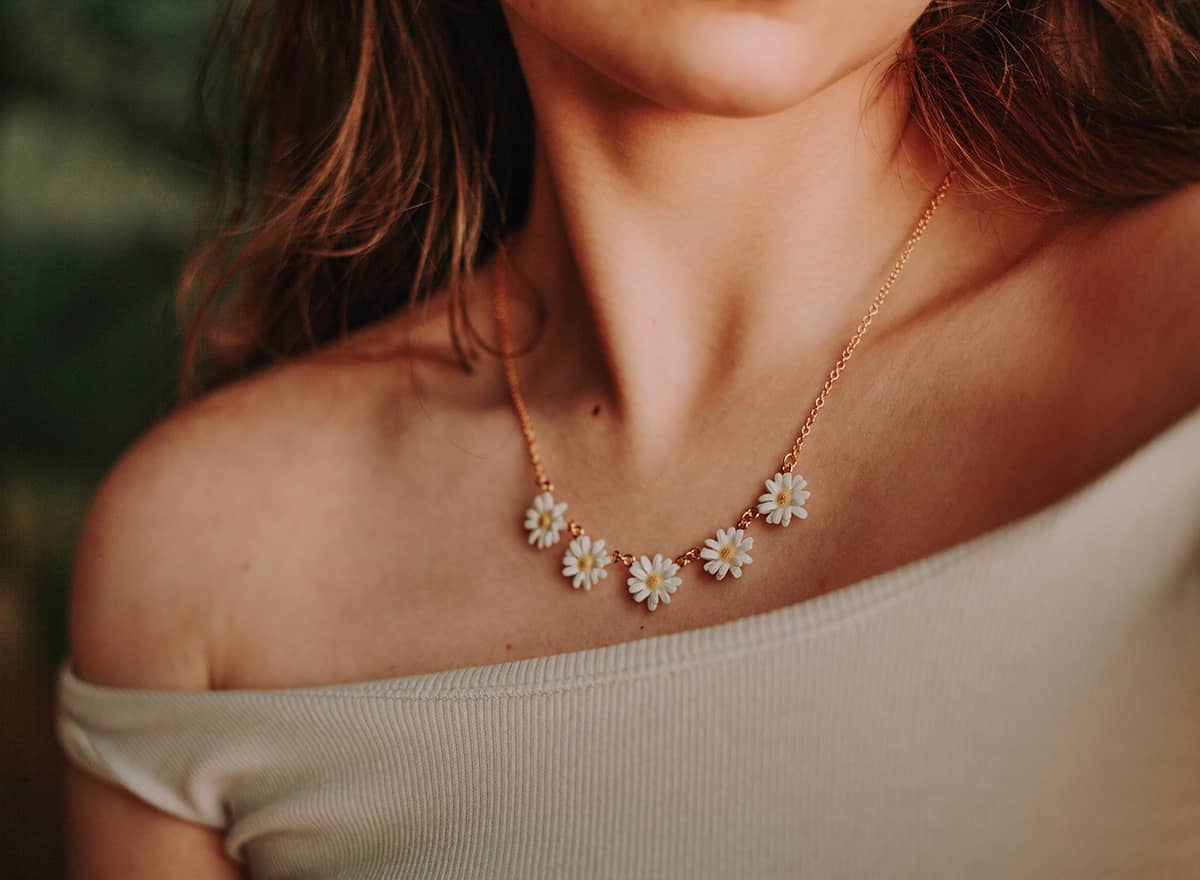 Close-up of a daisy necklace worn on a woman's neck