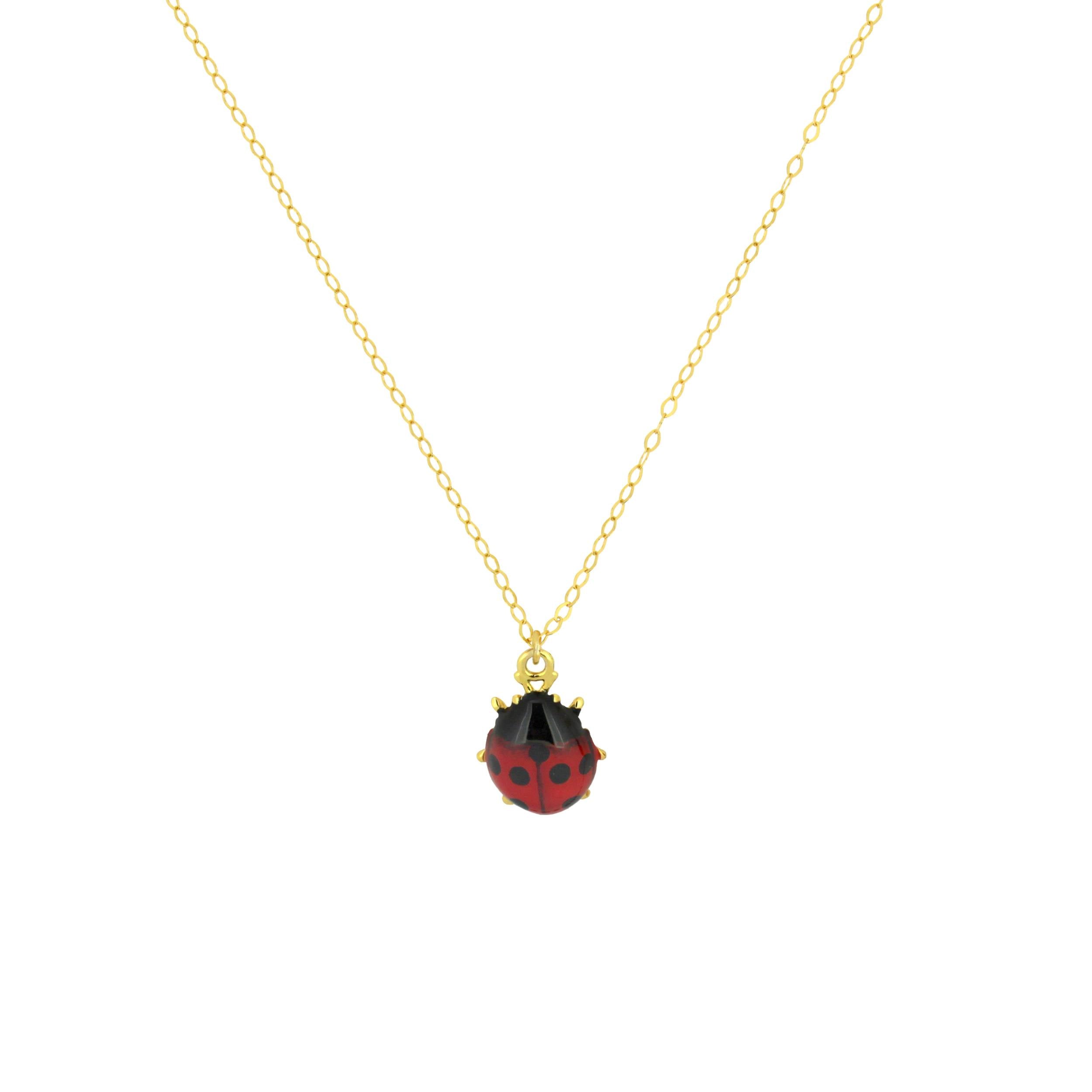 Gold chain necklace with a red and black ladybug charm.