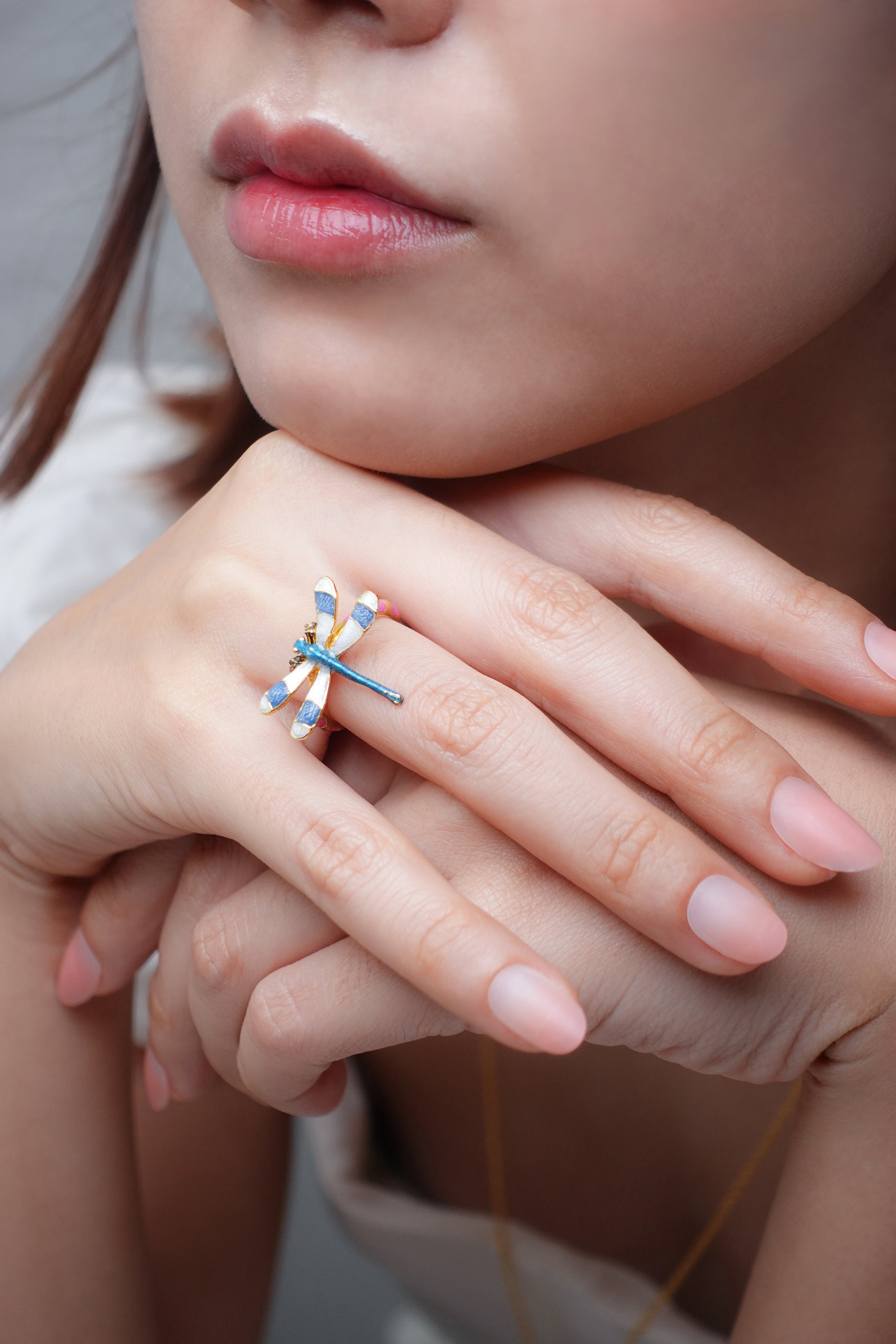 Close-up of a woman wearing a dragonfly ring on her finger.