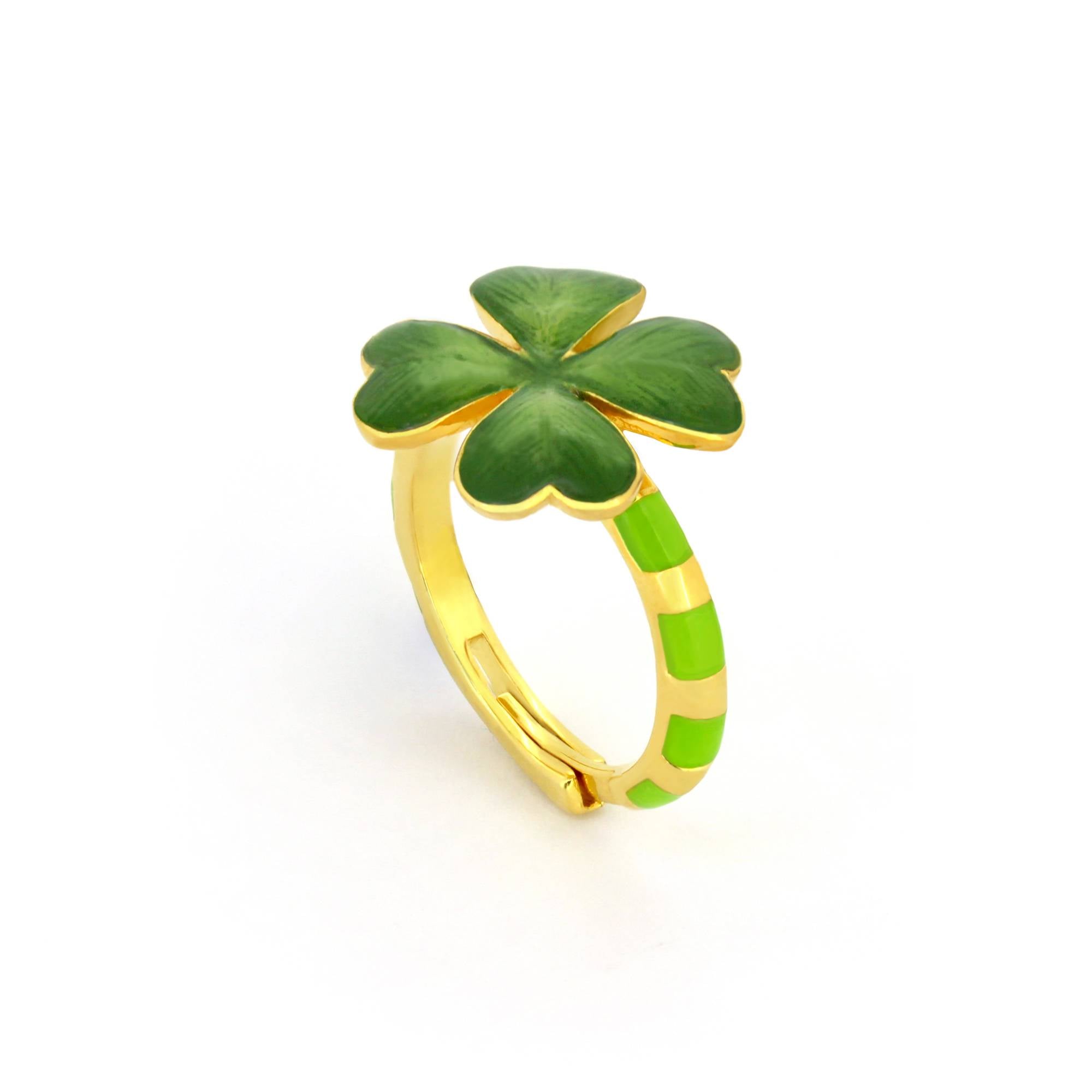 A gold ring featuring a green four-leaf clover design, with a striped band in green and gold accents.