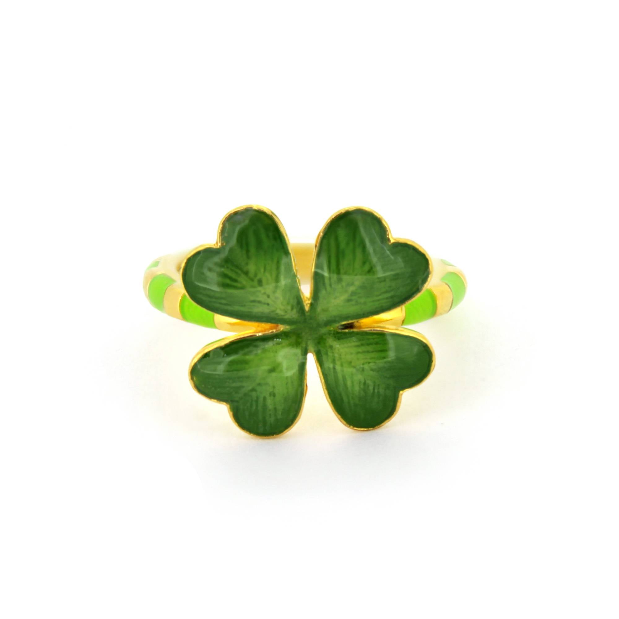 A gold ring featuring a green four-leaf clover design, with a striped band in green and gold accents.