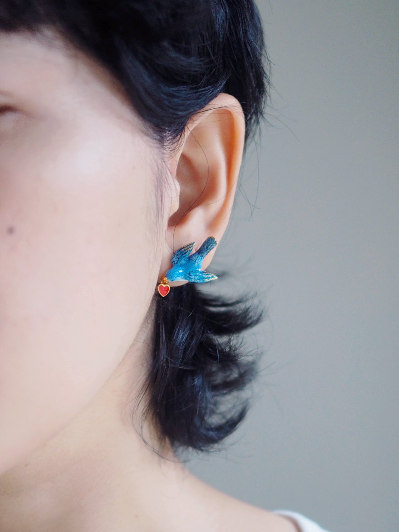 Woman wearing beautiful earring featuring a bird designs