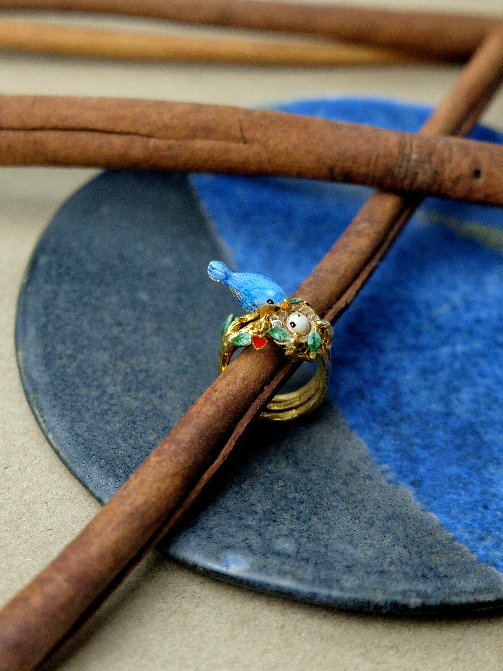 Beautifully crafted ring featuring a blue bird and baby bird in the nest design.