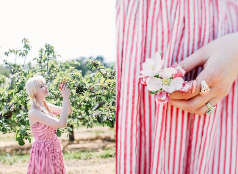 A woman in a summer outfit wears a cute unicorn ring while holding flowers.