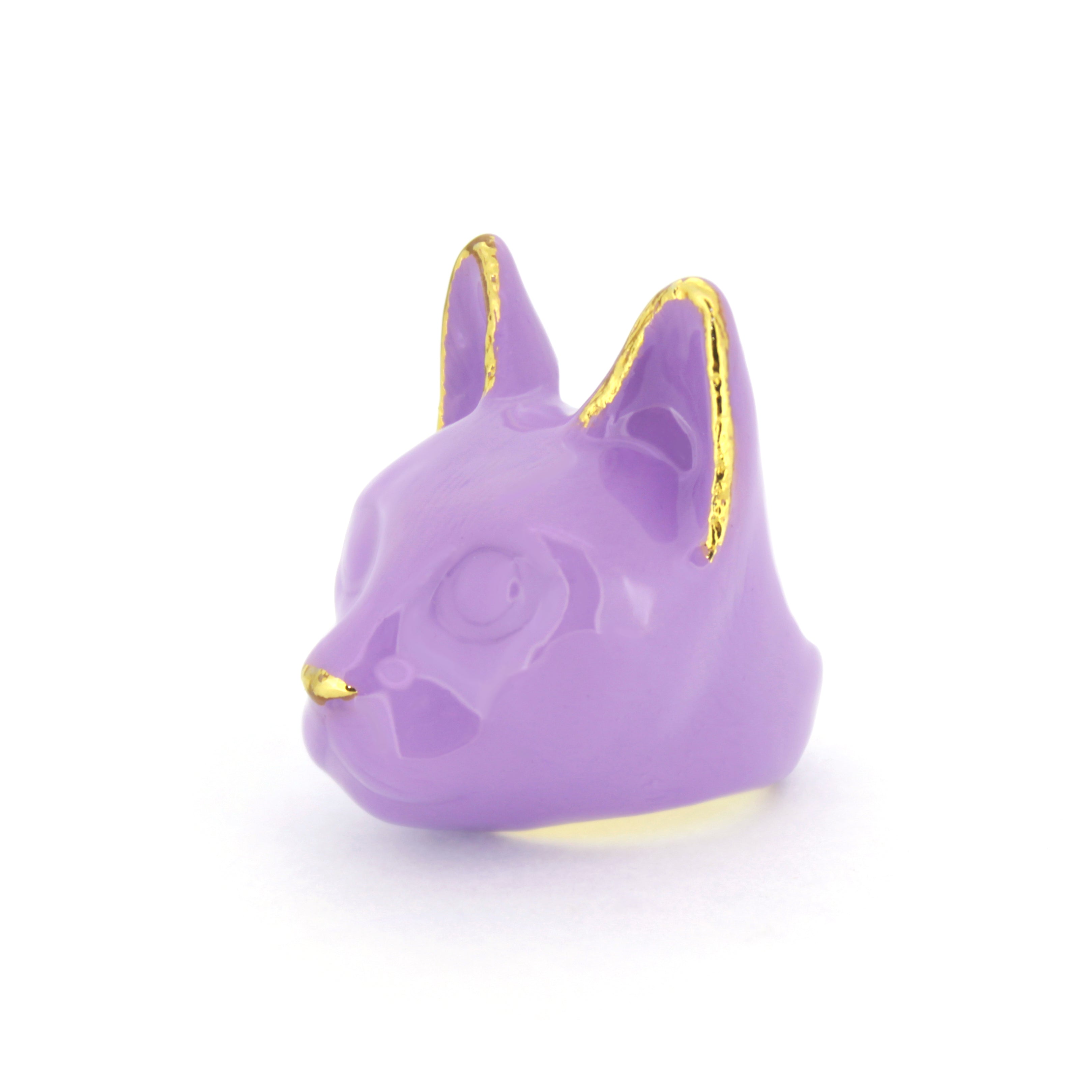 A purple cat face ring with gold accents on the ears and a small gold nose.