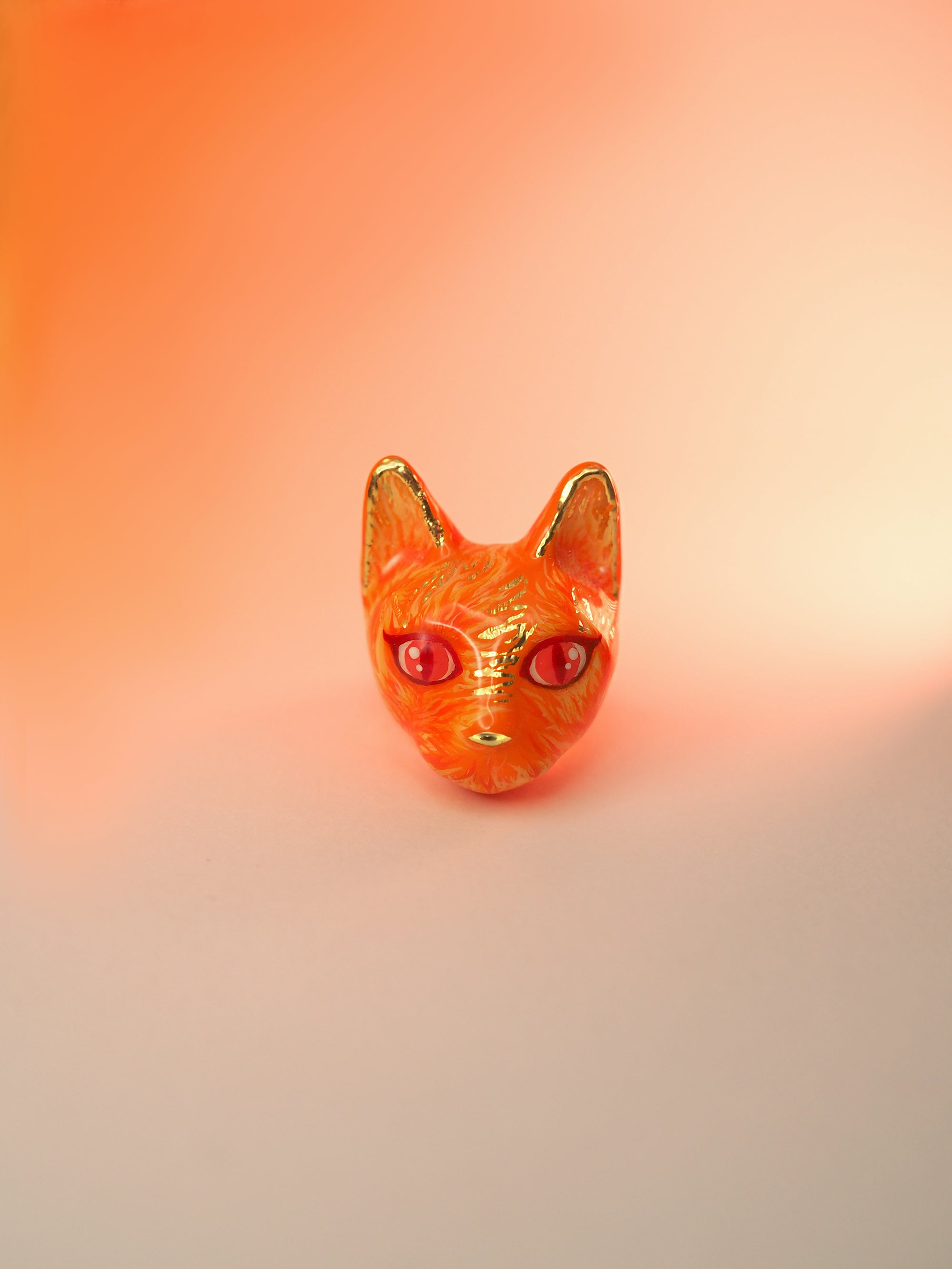 Hand-painted ring designed as a cat's face in orange, featuring fiery details.