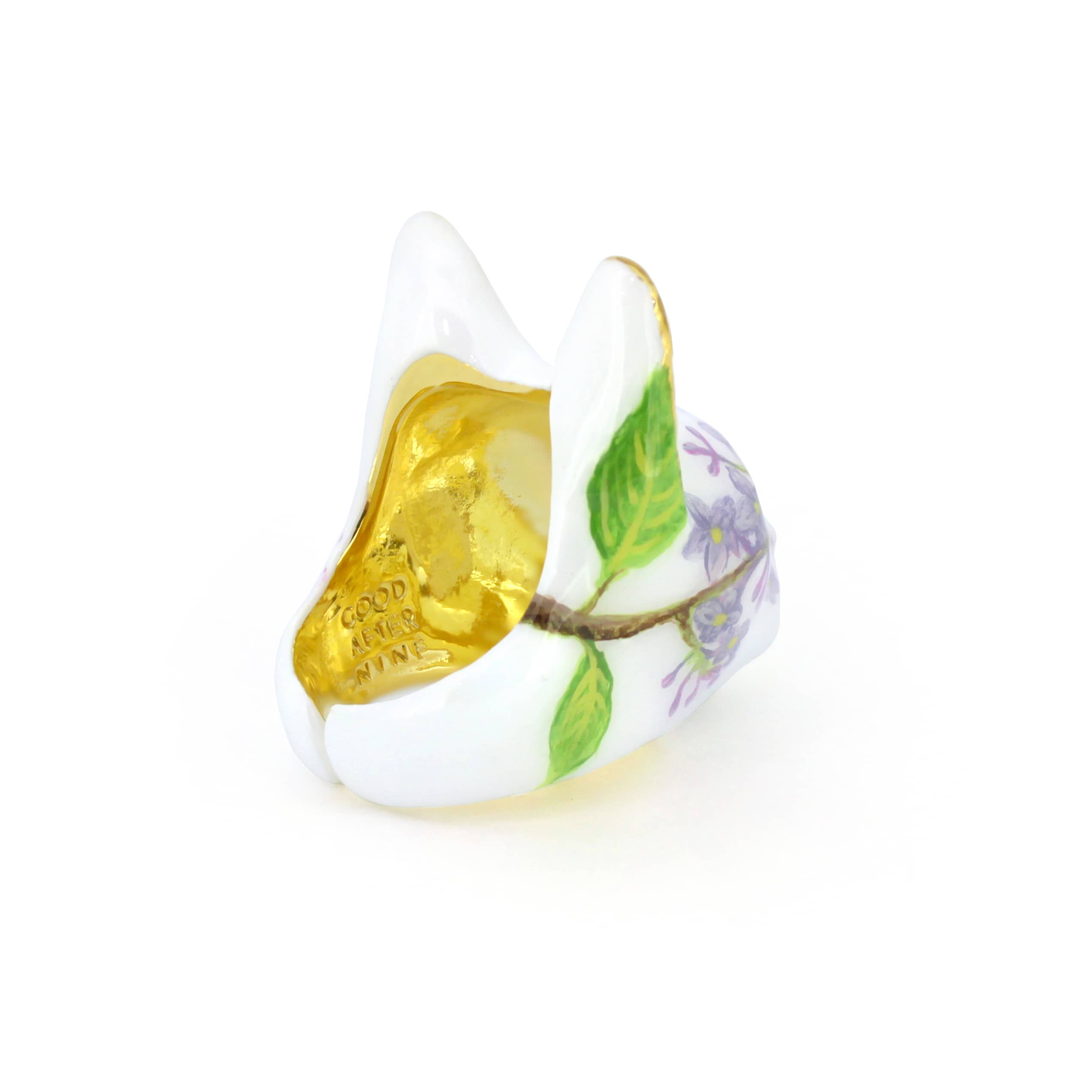 A whimsical cat head ring with purple flower designs, sparkling gold accents, and charming purple eyes, perfect for cat lovers.