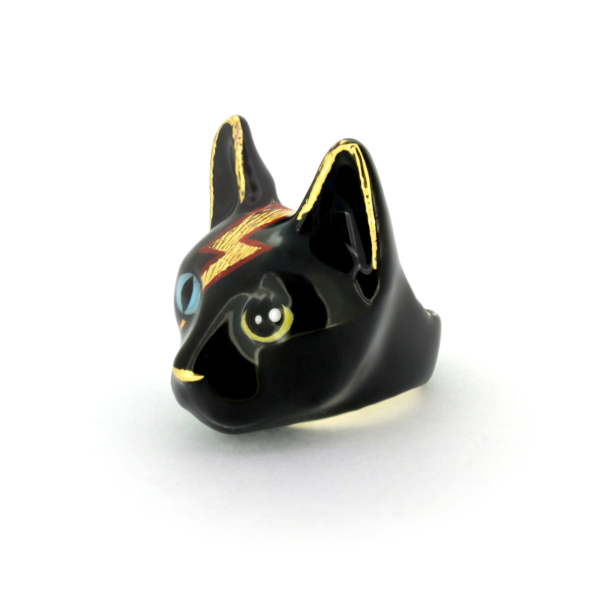 A unique black cat ring with blue and yellow eyes and a lightning bolt design.