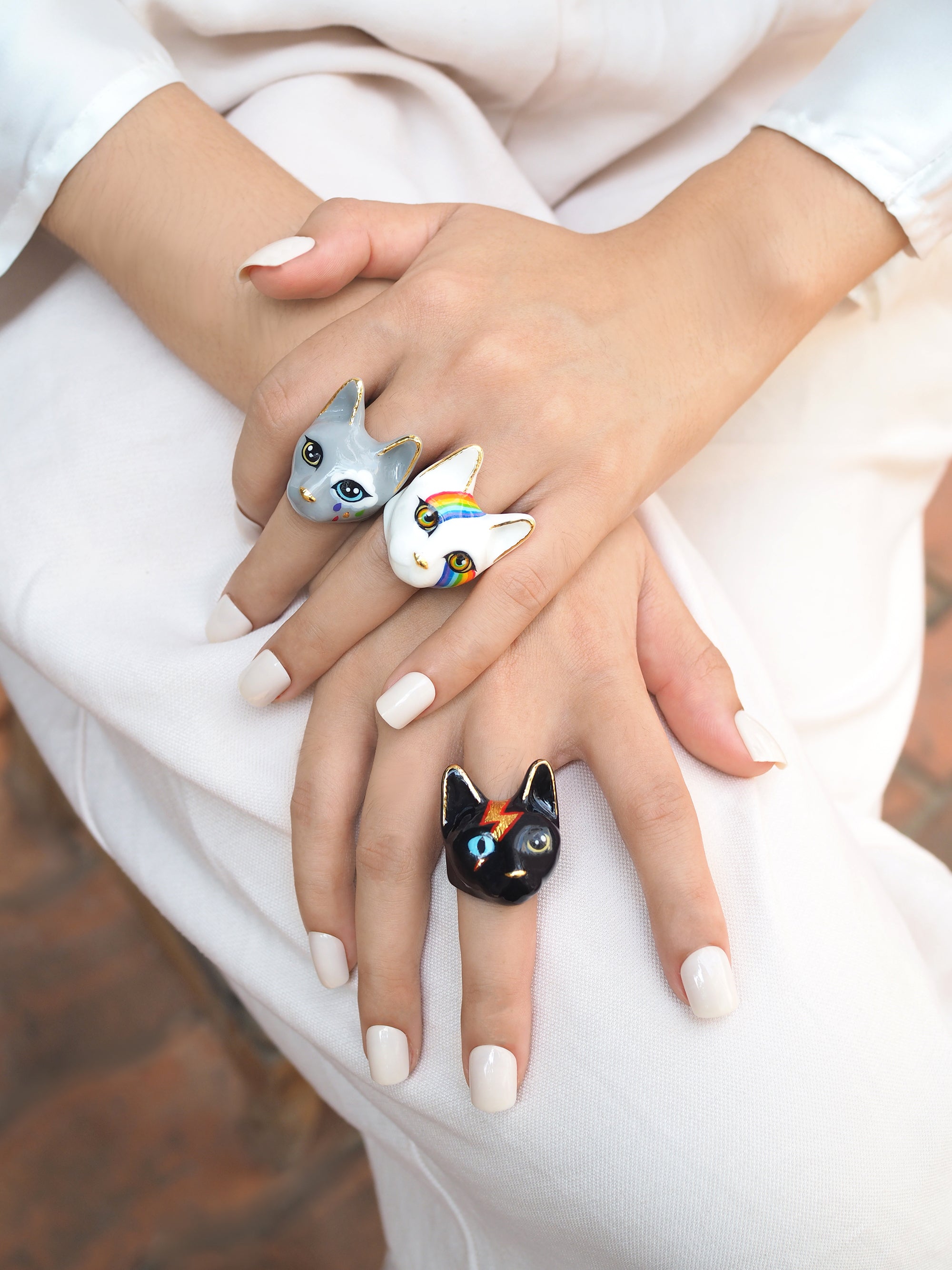 Collection of unique  cat rings showcasing designs on fingers, perfect for cat lovers.