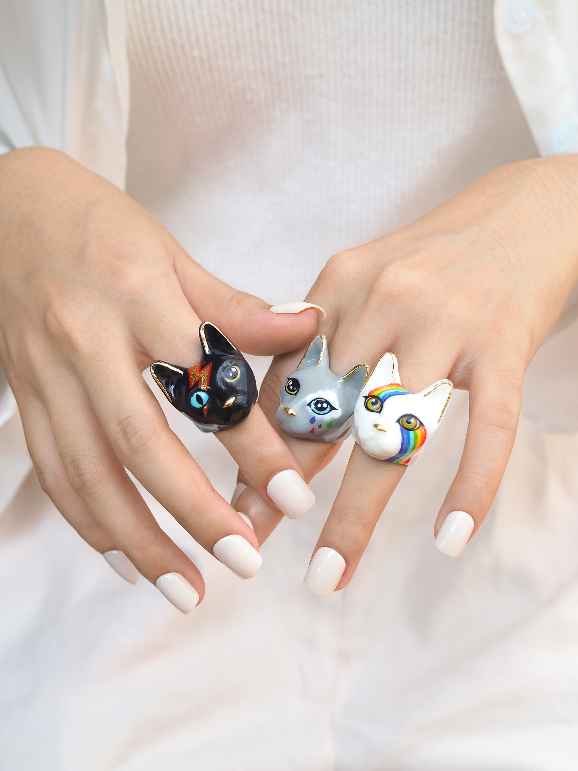 Collection of unique  cat rings showcasing designs on fingers, perfect for cat lovers.