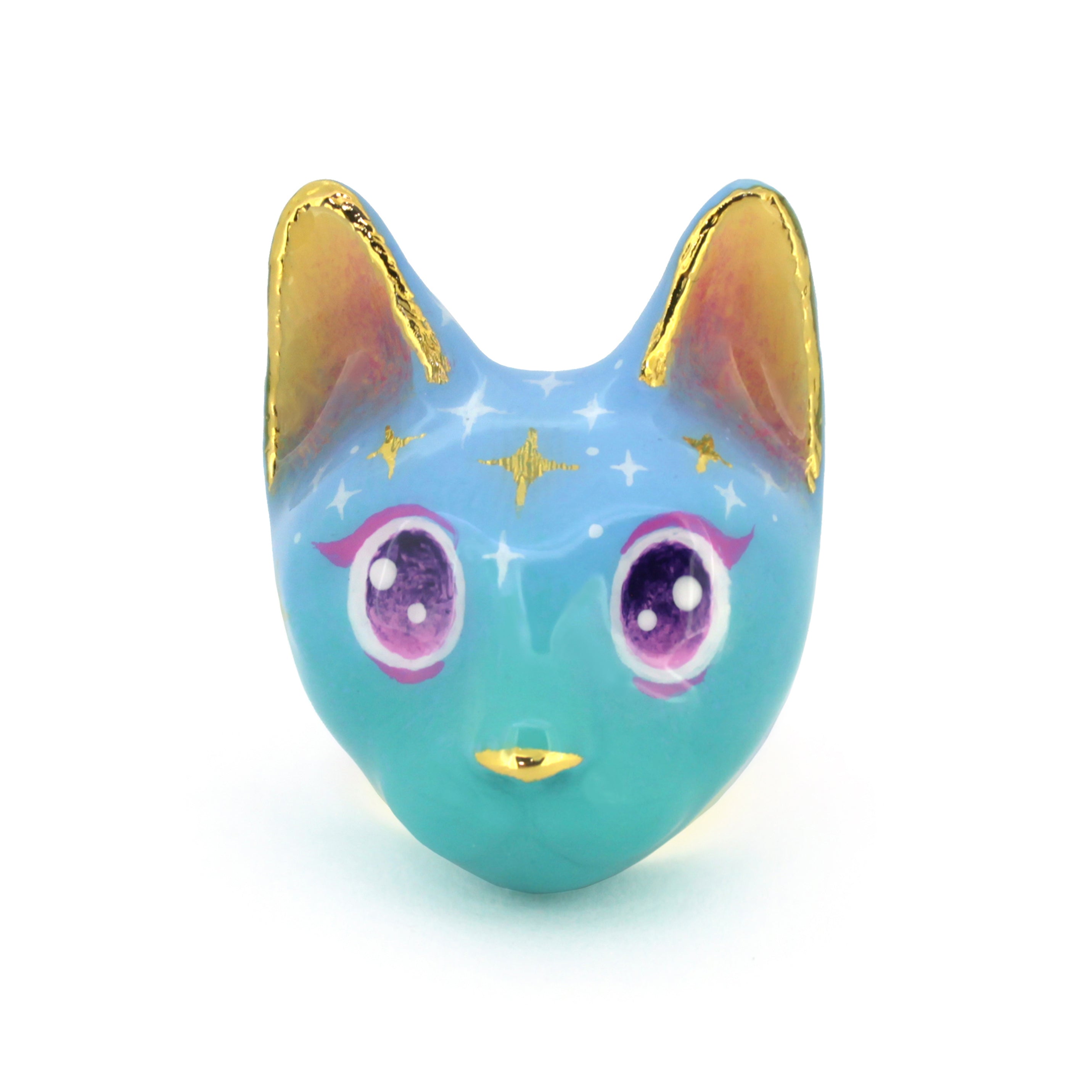 A whimsical ring with a cat's face design in a soft blue color featuring yellow ears and large, sparkling purple eyes and star-like patterns on its forehead