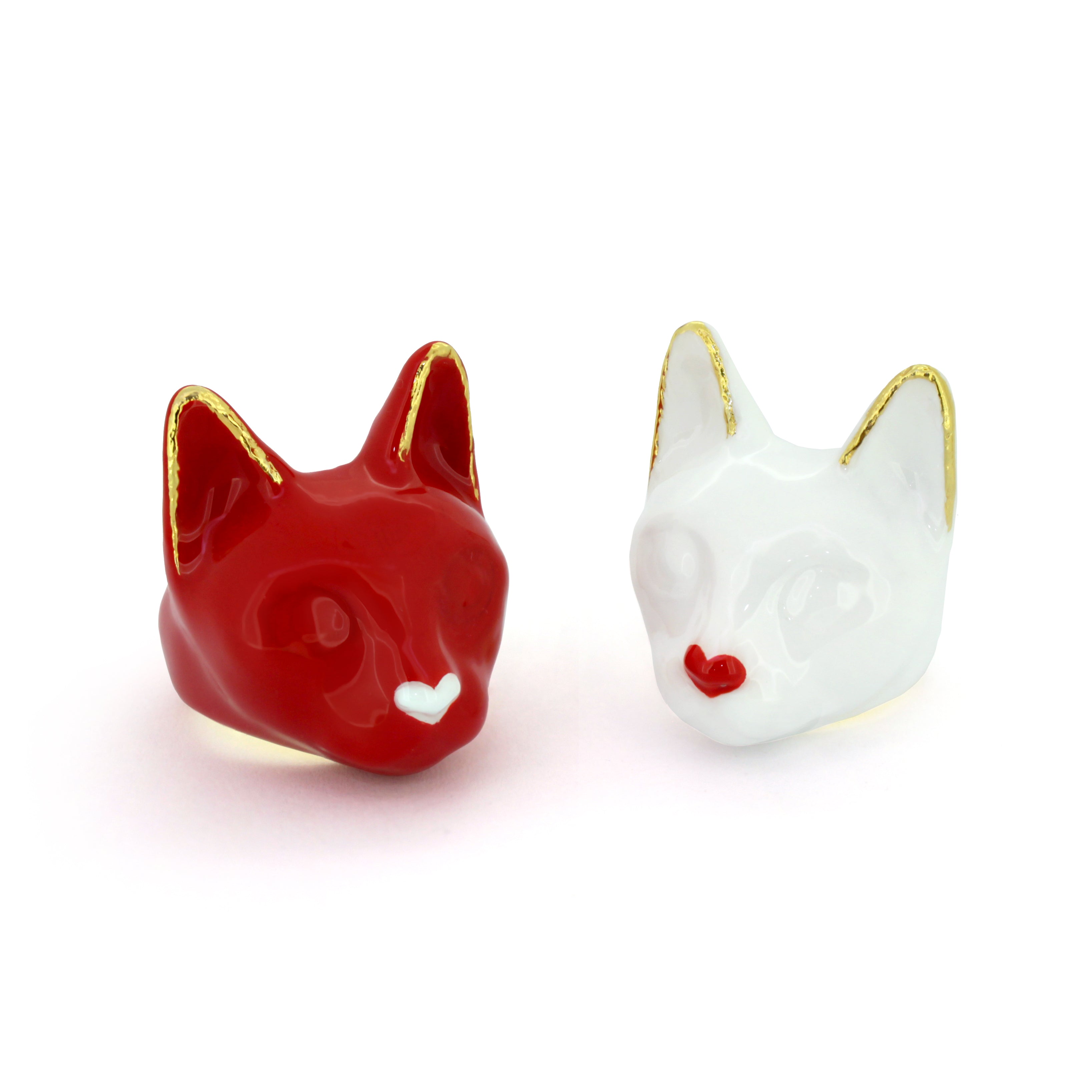 Two Valentine's-themed cat rings: one white with a small red heart and one red with a small white heart.