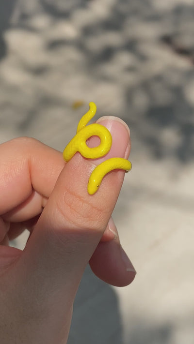 Fun and vibrant snake rings in different colors on a hand.