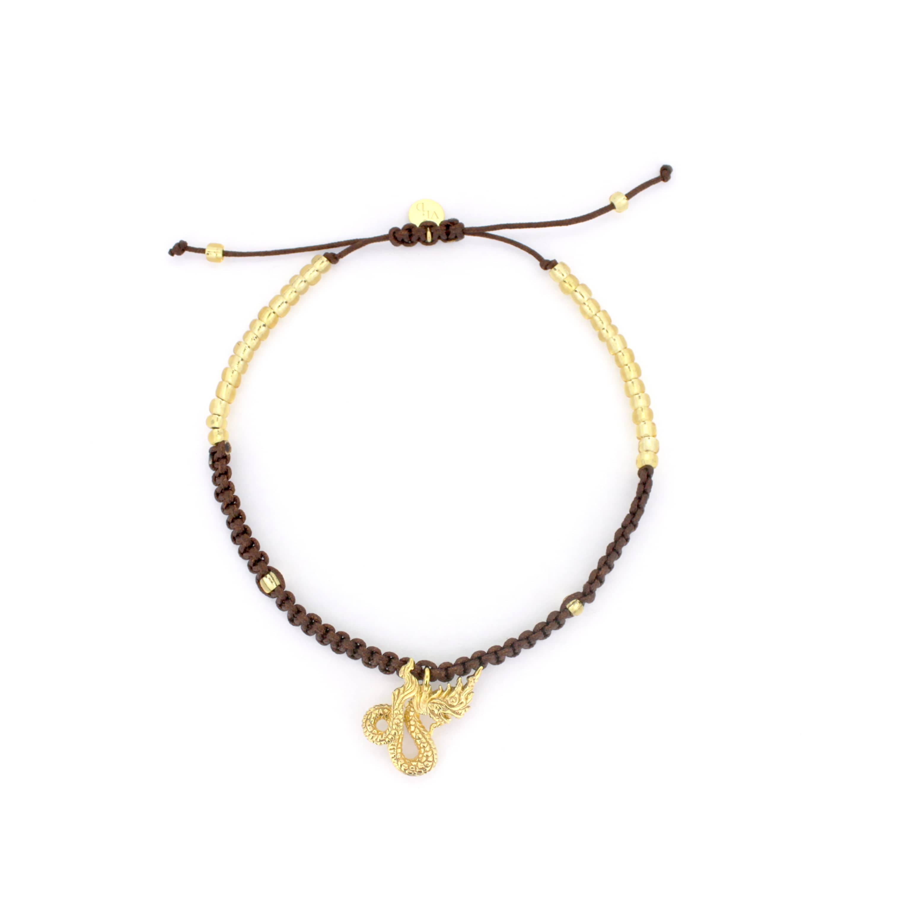 A handcrafted bracelet featuring a brown woven design material adorned with a gold Naga charm.