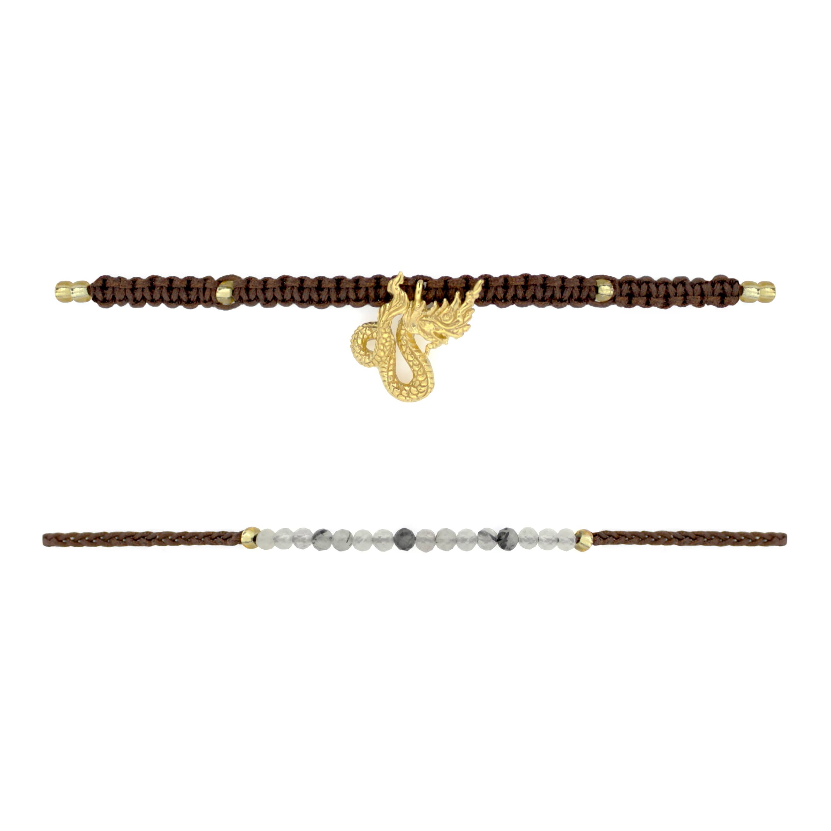 Set of two bracelets the top bracelet featuring a brown woven design material adorned with a gold Naga charm. The bottom bracelet features a series of grey and white beads with a simple woven brown band.