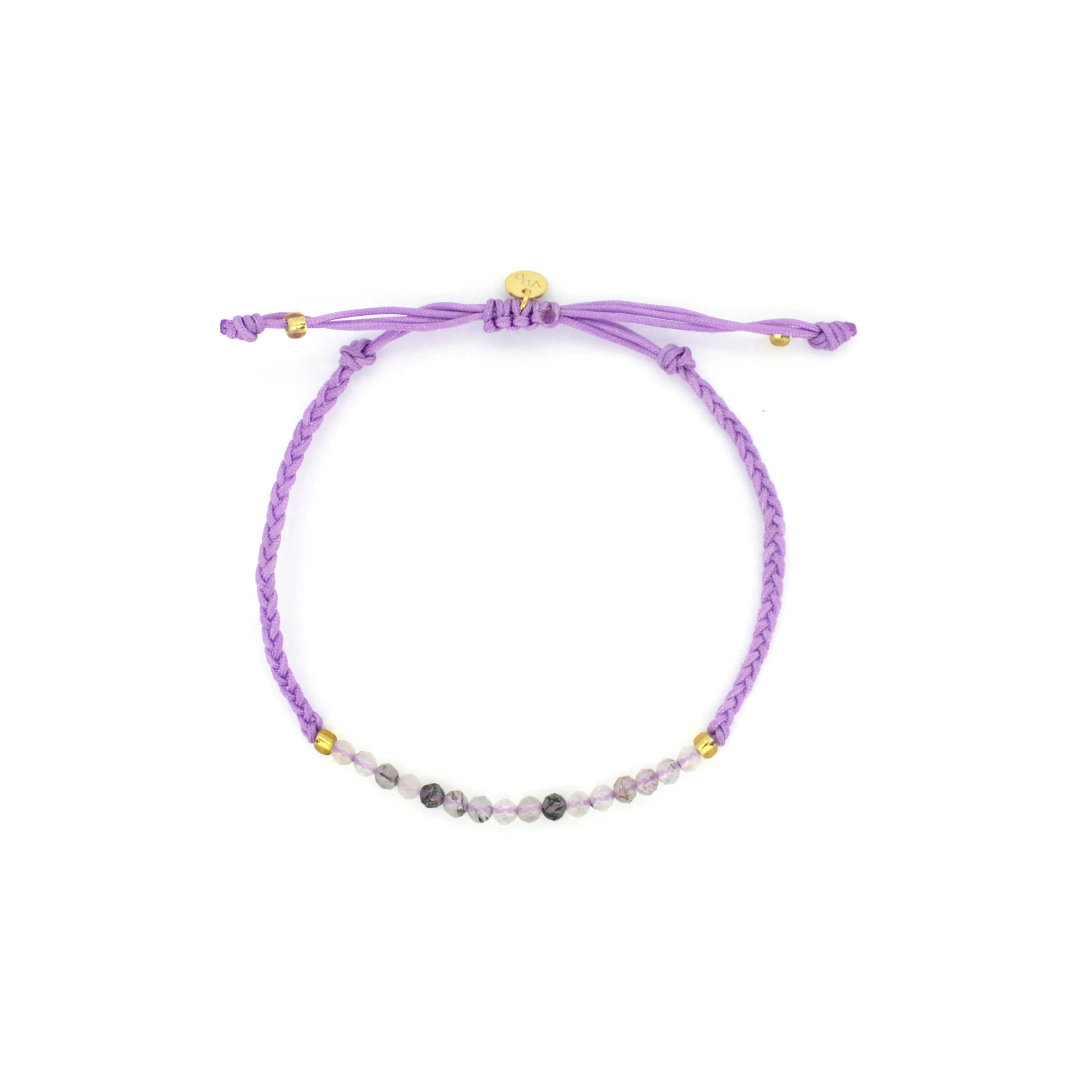 A bracelet features a series of grey and white beads with a simple woven purple band.