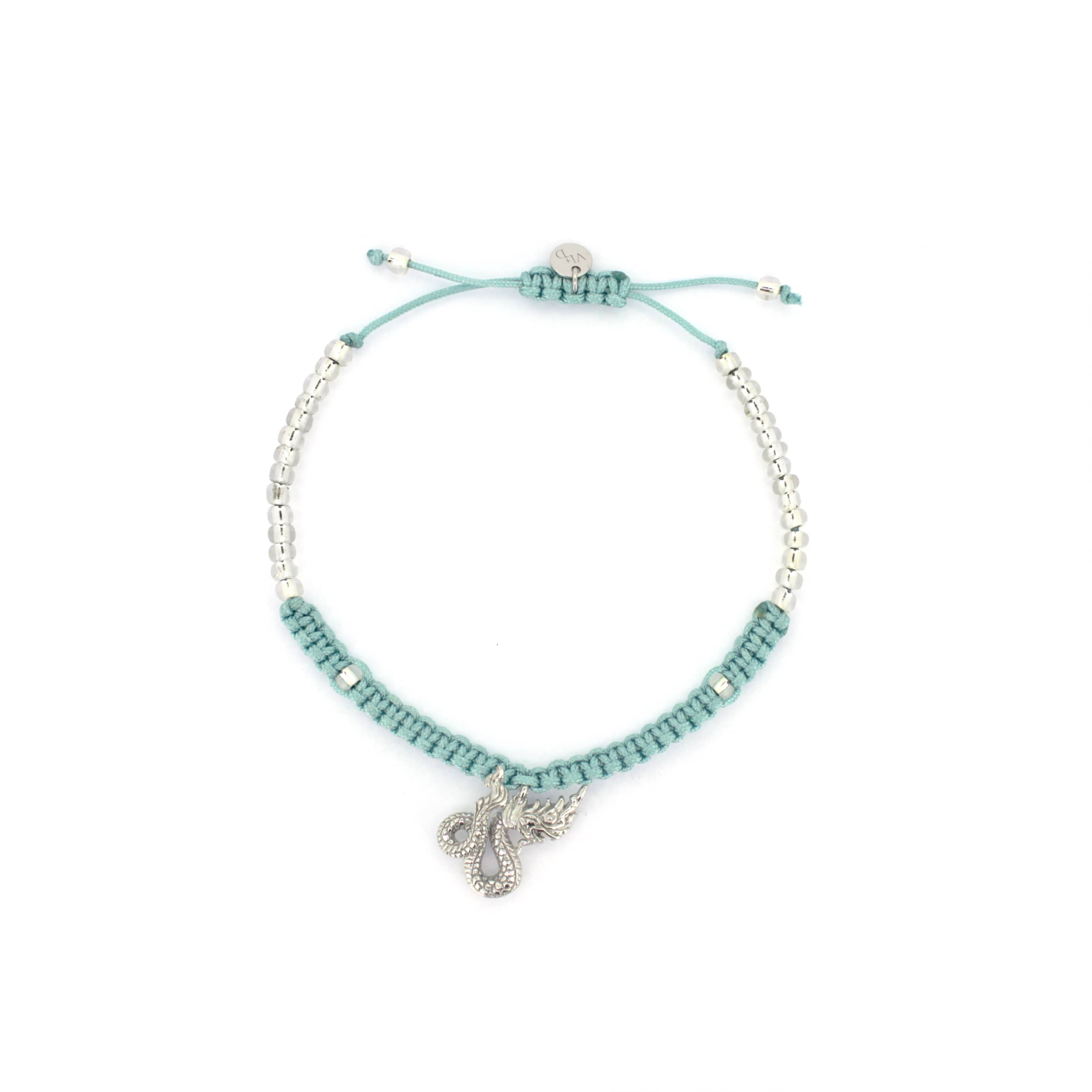 A light blue bracelets with a silver Naga charm