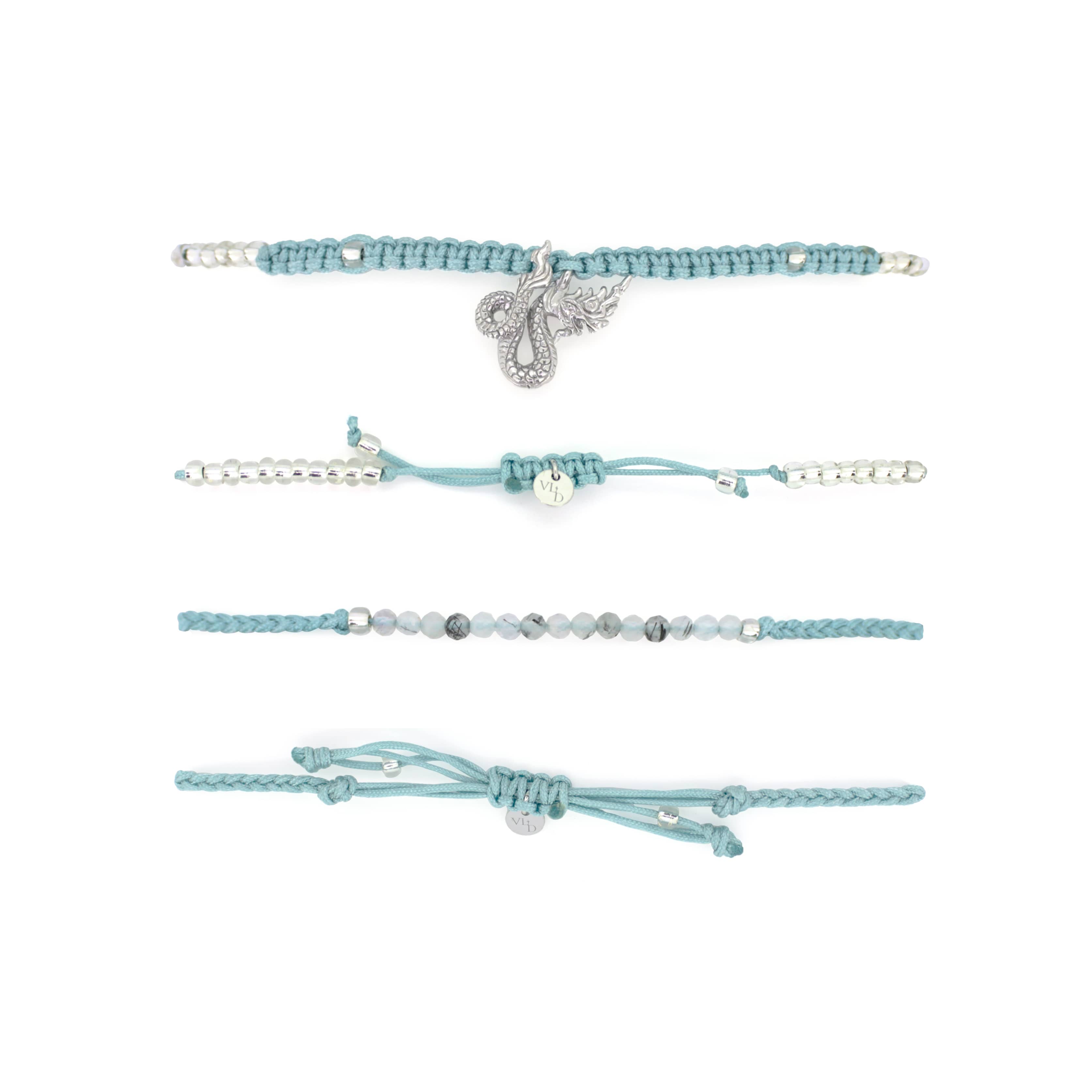 Set of two light blue bracelets: one with a silver Naga charm, the other with grey quartz-faced beads.