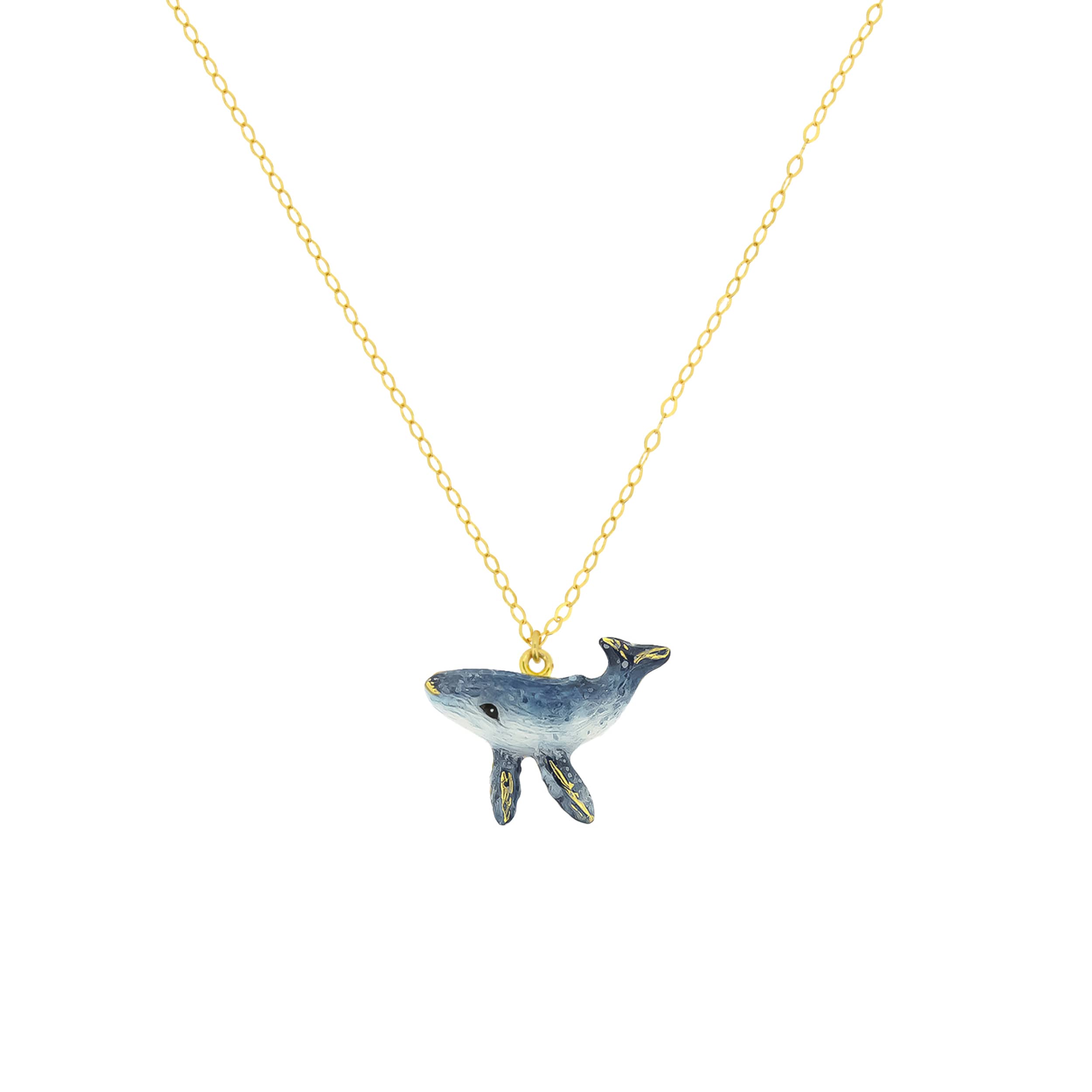 Gold necklace with a blue whale pendant.