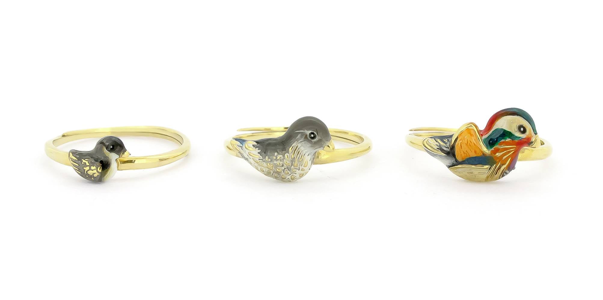 A set of three gold rings featuring colorful, intricately designed mandarin duck motifs in varying sizes.