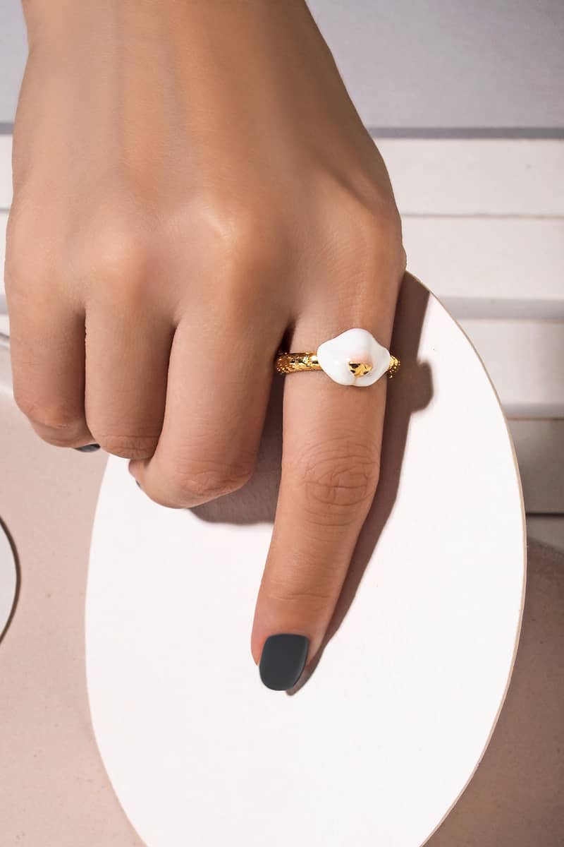 Close up of a hand showcasing a gold ring featuring a cat's nose design, perfect for cat lovers.