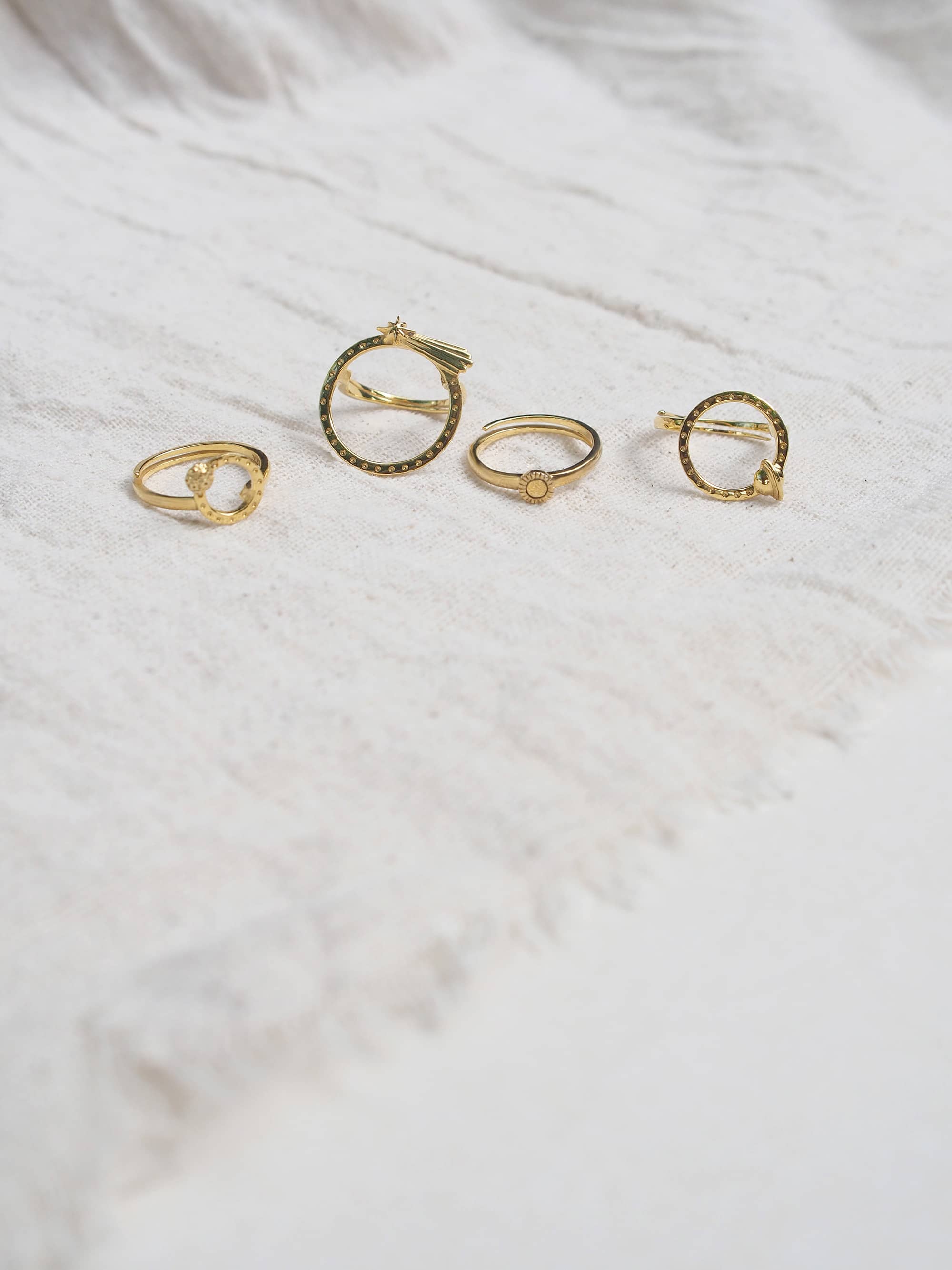 Charming solar-system inspired gold ring set featuring a moon, shooting star, Sun, and Saturn with circular designs and intricate details.