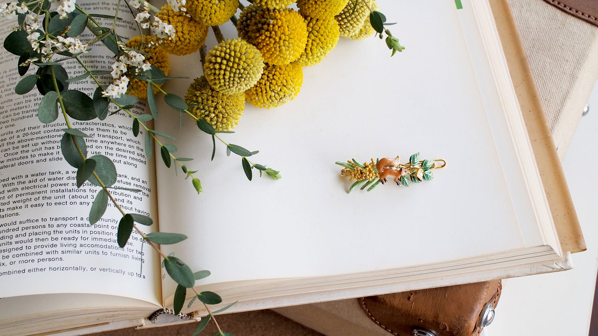 Nature-inspired earrings with a fox butterfly and botanical details.