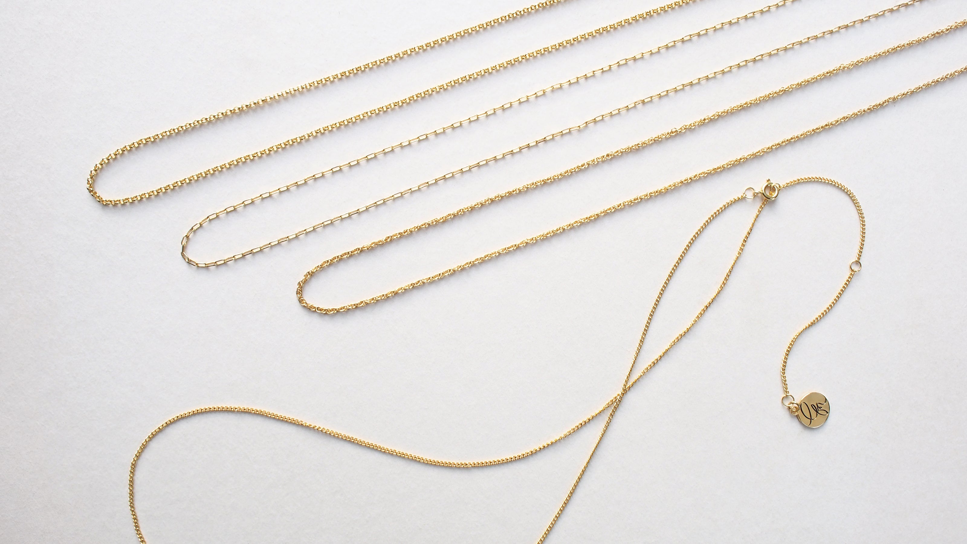 Gold color initial necklaces showcasing different chain styles.