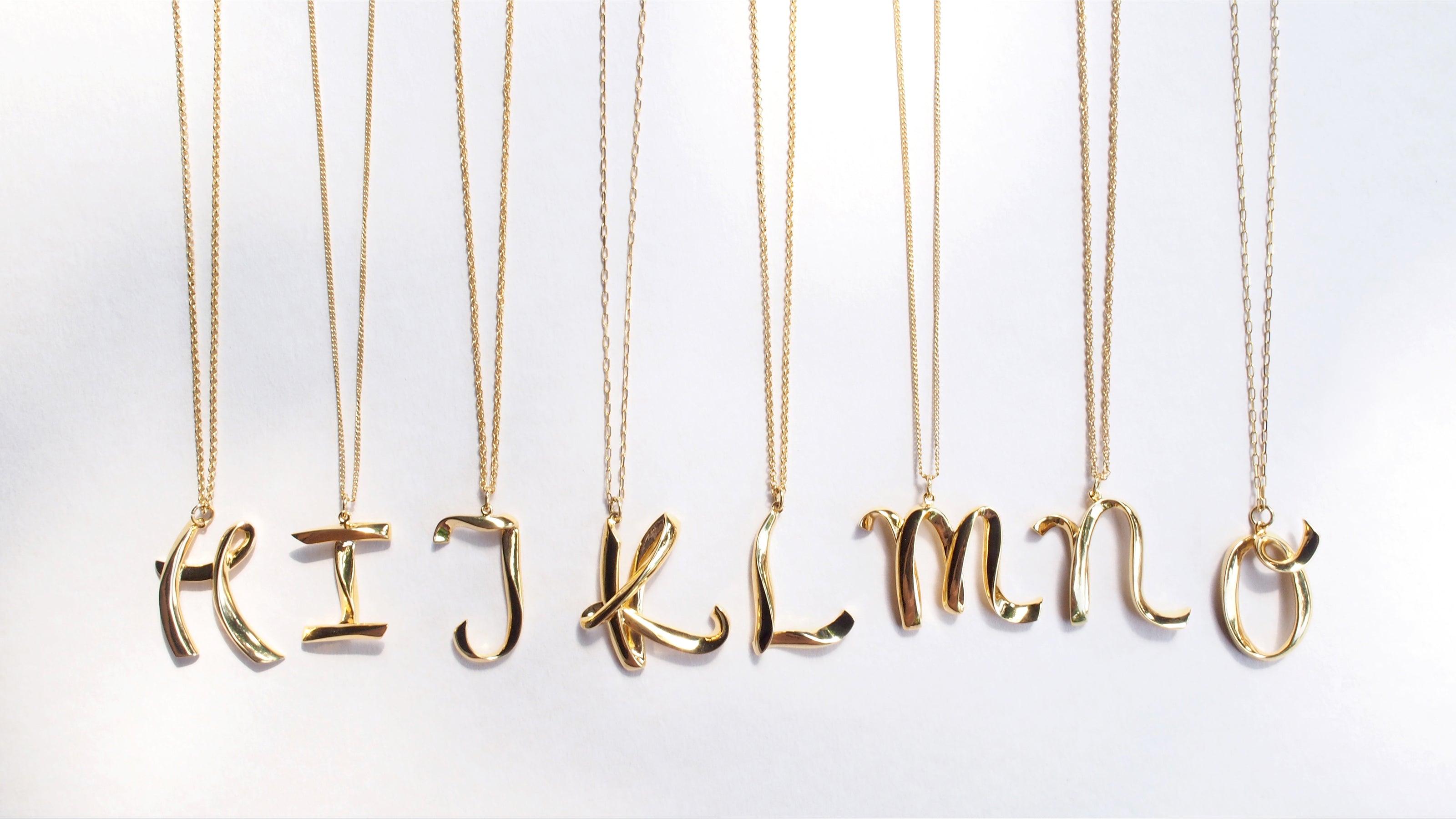 Gold-colored necklaces with charming letters H, I, J, K, L, M, N and O on various chain styles.