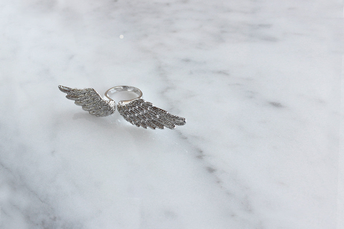 Unique ring featuring a winged design on a marble surface.