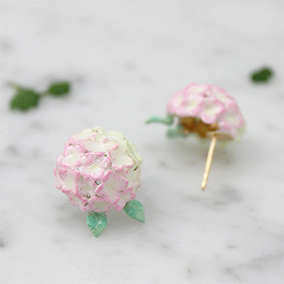 Beautiful floral earrings with pink hydrangea designs placed on marble background.