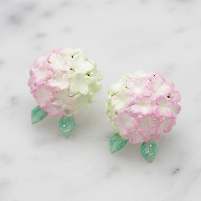 Beautiful floral earrings with pink hydrangea designs placed on marble background.