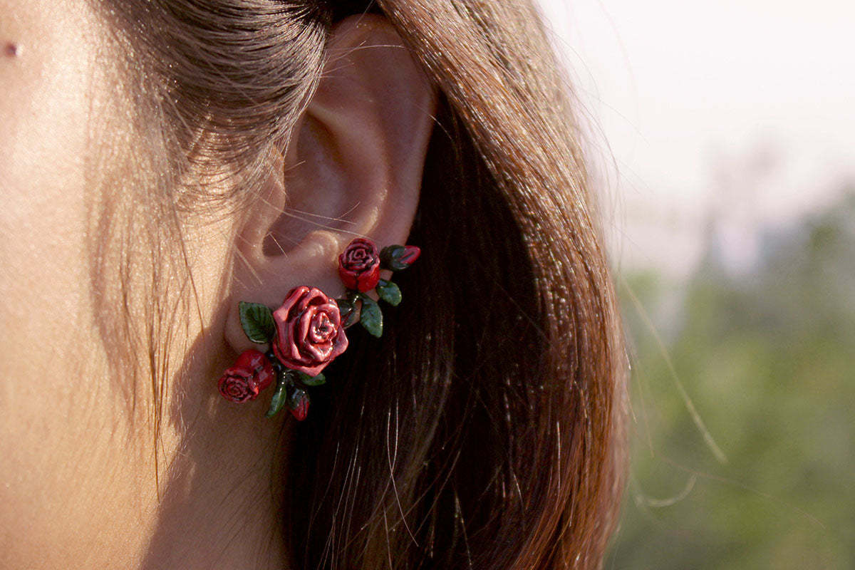 Close-up of stunning red rose earring worn on a woman.