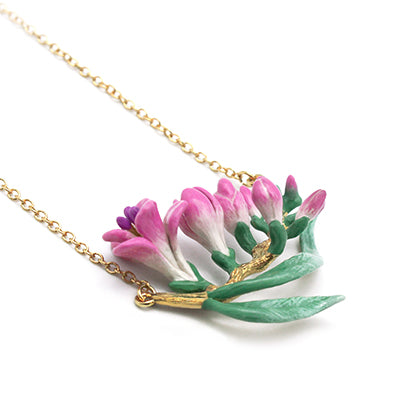 Nature-inspired necklace adorned with delicate pink flowers and leaves.