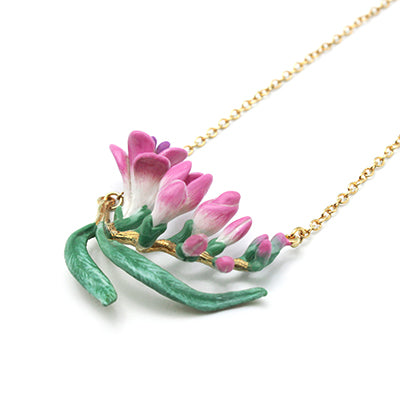 Nature-inspired necklace adorned with delicate pink flowers and leaves.