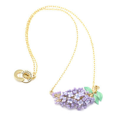 Delicate gold necklace featuring a cluster of lilac flowers and green leaves, elegantly crafted for floral charm.