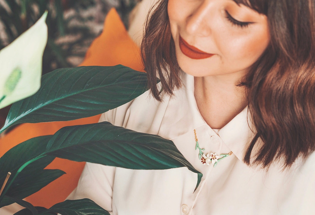 A close-up of a women collarbone wearing a lily necklace, perfect for flower lovers.