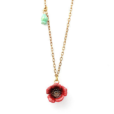 Gold necklace featuring a red flower pendant and a small green accent