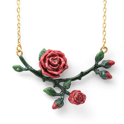 A floral necklace featuring red roses and green leaves on a gold chain.