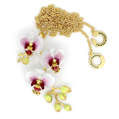 A gold necklace with three white flowers and golden accents pendant, perfect for summer fashion.