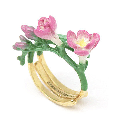 Handcrafted gold ring adorned with delicate pink flowers, showcasing craftsmanship.