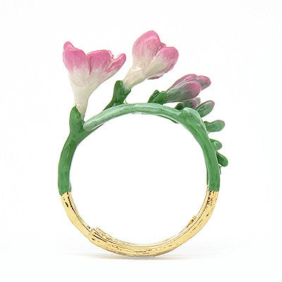 Handcrafted gold ring adorned with delicate pink flowers, showcasing craftsmanship.