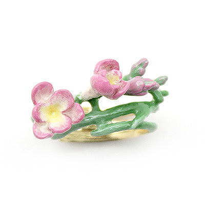 Handcrafted gold ring adorned with delicate pink flowers, showcasing craftsmanship.