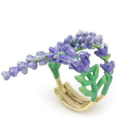 A whimsical gold ring featuring delicate lavender flowers and green leaves, curved around the band.