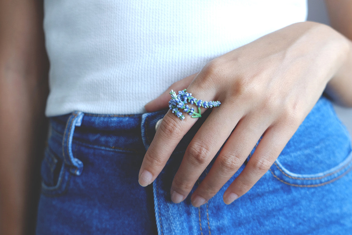 A close-up of a hand adorned with lavender ring, ideal for summer fashion.