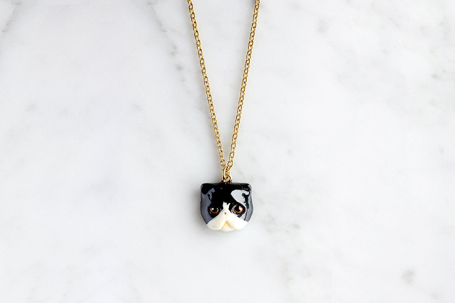 Charming black white Persian cat pendant necklace with gold chain, perfect for cat lovers.